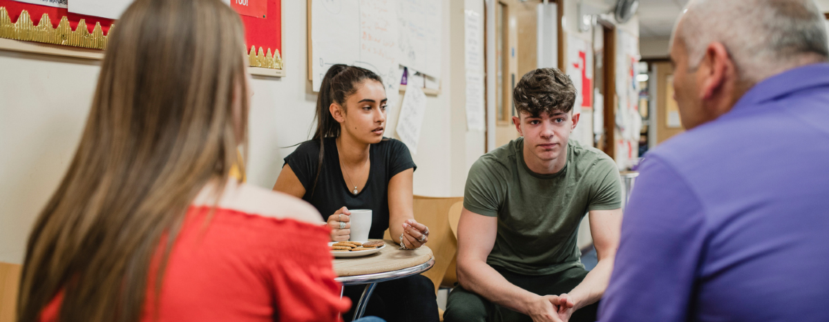 Two young people having a discussion with an older man and woman